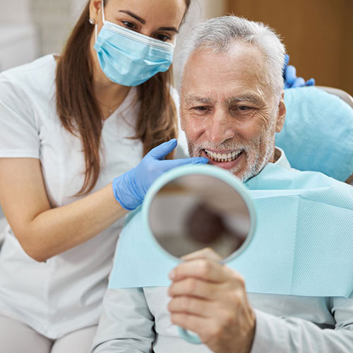 A dental implant patient checks his teeth